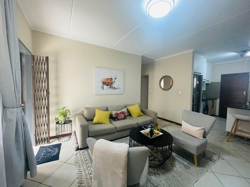 Open plan living area featuring tiled flooring and a seamless transition into the adjacent kitchen space.