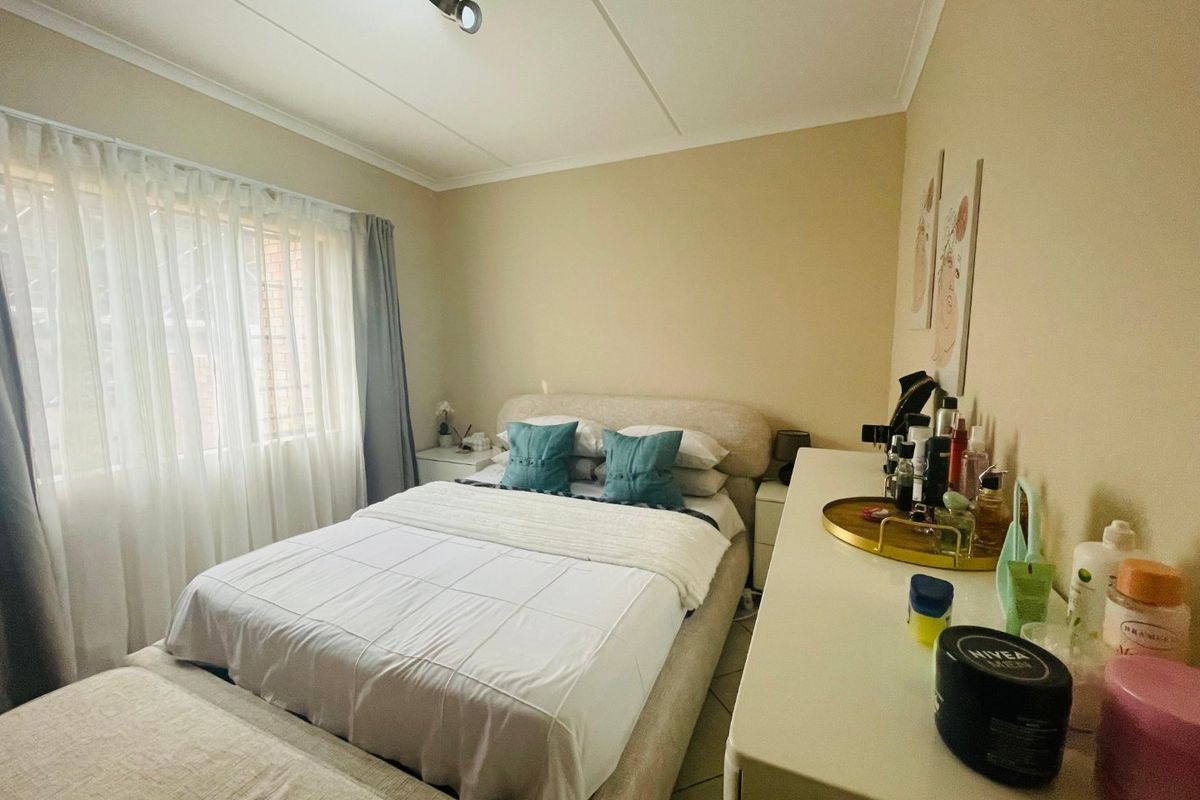 A functional bedroom featuring tiled flooring and a ceiling-mounted light fixture, offering a neutral base for personalization.