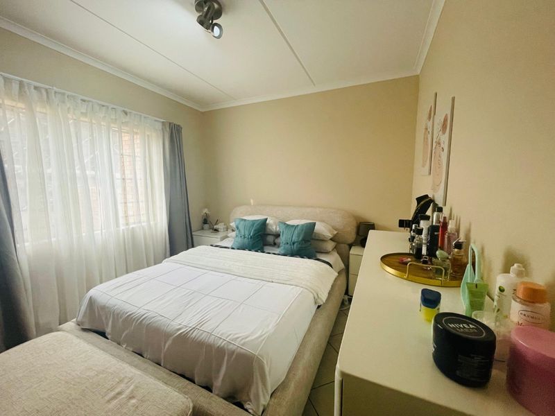 A functional bedroom featuring tiled flooring and a ceiling-mounted light fixture, offering a neutral base for personalization.