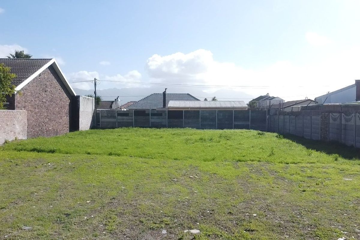 A vacant residential plot featuring perimeter walls and precast concrete fencing, offering a clear space for potential development.