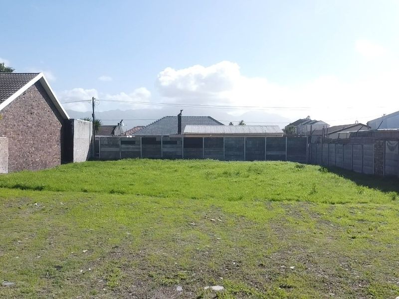 A vacant residential plot featuring perimeter walls and precast concrete fencing, offering a clear space for potential development.