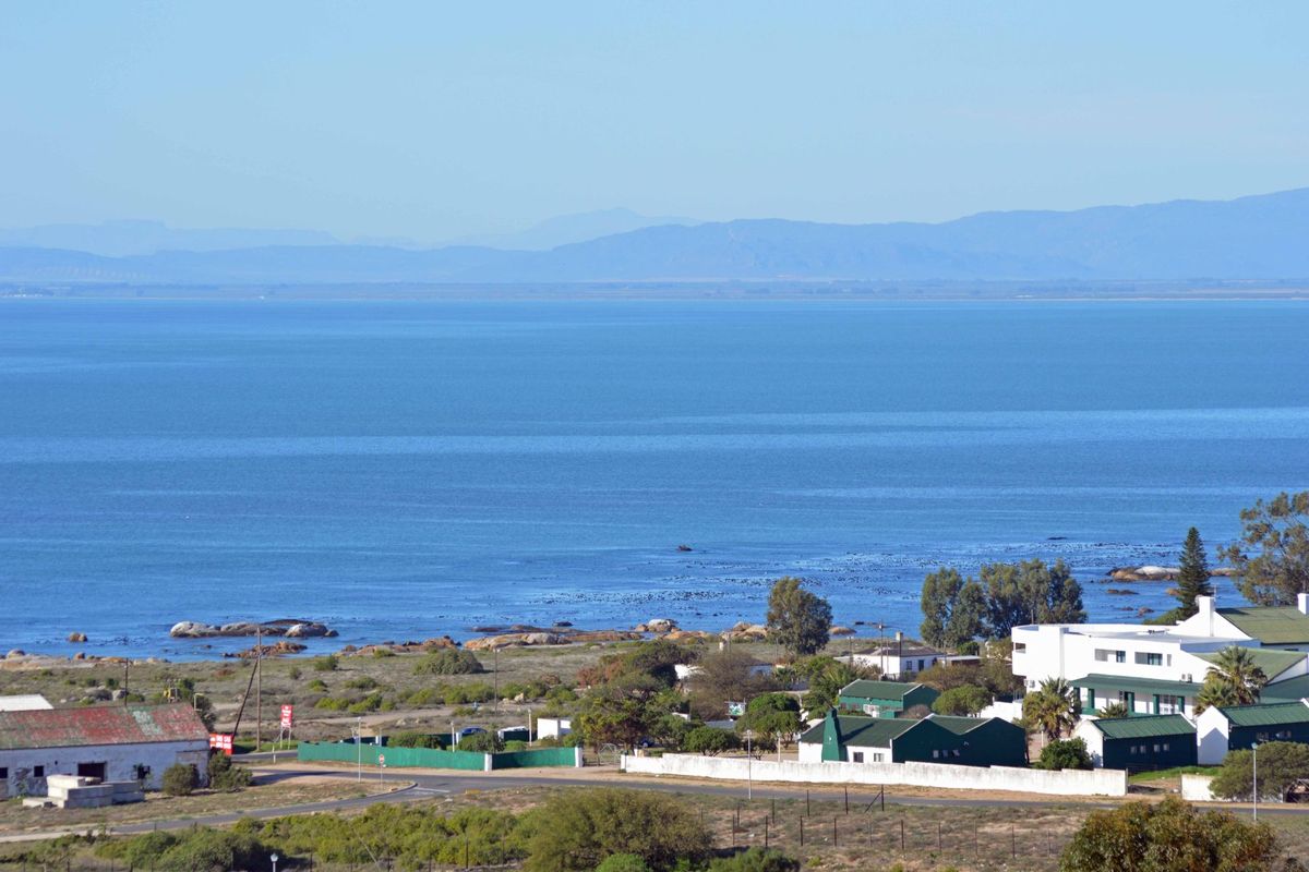 A scenic elevated view overlooking the coastline, ocean, and surrounding residential area.