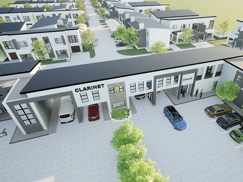 An aerial view of a modern residential complex featuring paved parking areas and contemporary architectural design.