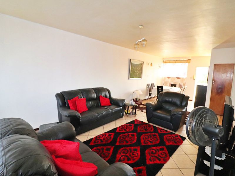 Open plan living and dining area featuring neutral wall finishes and tiled flooring, providing a versatile space for relaxation and entertaining.