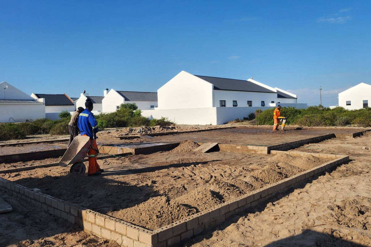 A construction site showing the initial foundation and masonry work for a new residential property.