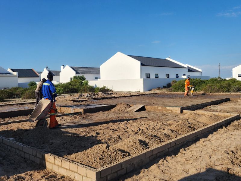 A construction site showing the initial foundation and masonry work for a new residential property.