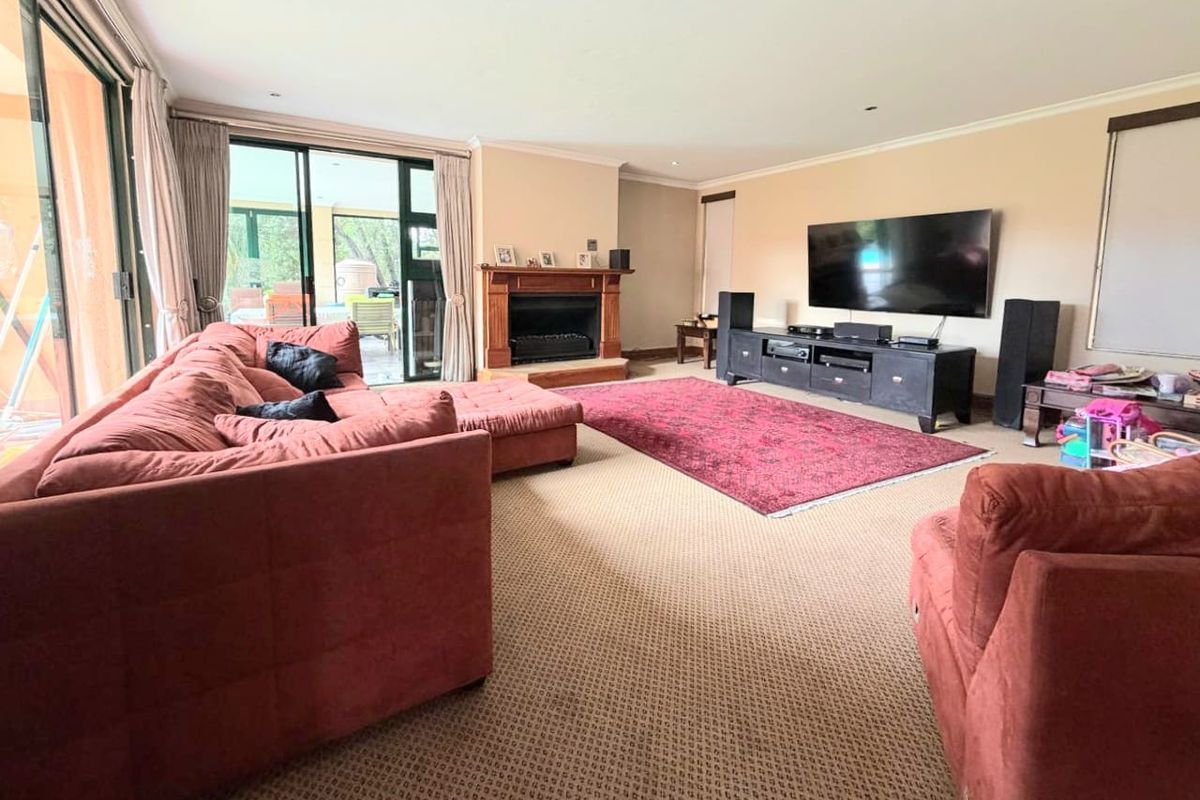 Spacious living room featuring a built-in fireplace, carpeted flooring, and large sliding glass doors providing access to the outdoor patio area.