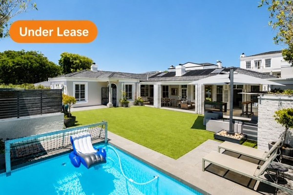 Spacious rear garden featuring a swimming pool, covered patio area, and well-maintained artificial lawn, perfect for outdoor entertaining.