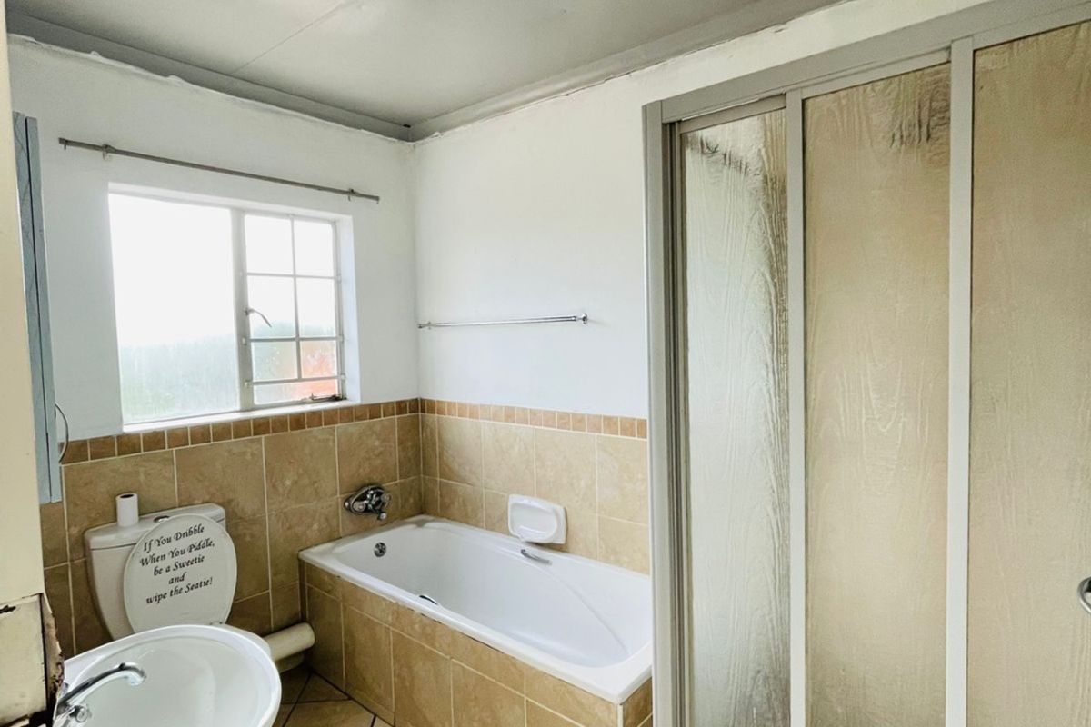 A dated bathroom featuring a pedestal basin, built-in bathtub, and a separate shower enclosure with tiled finishes throughout.