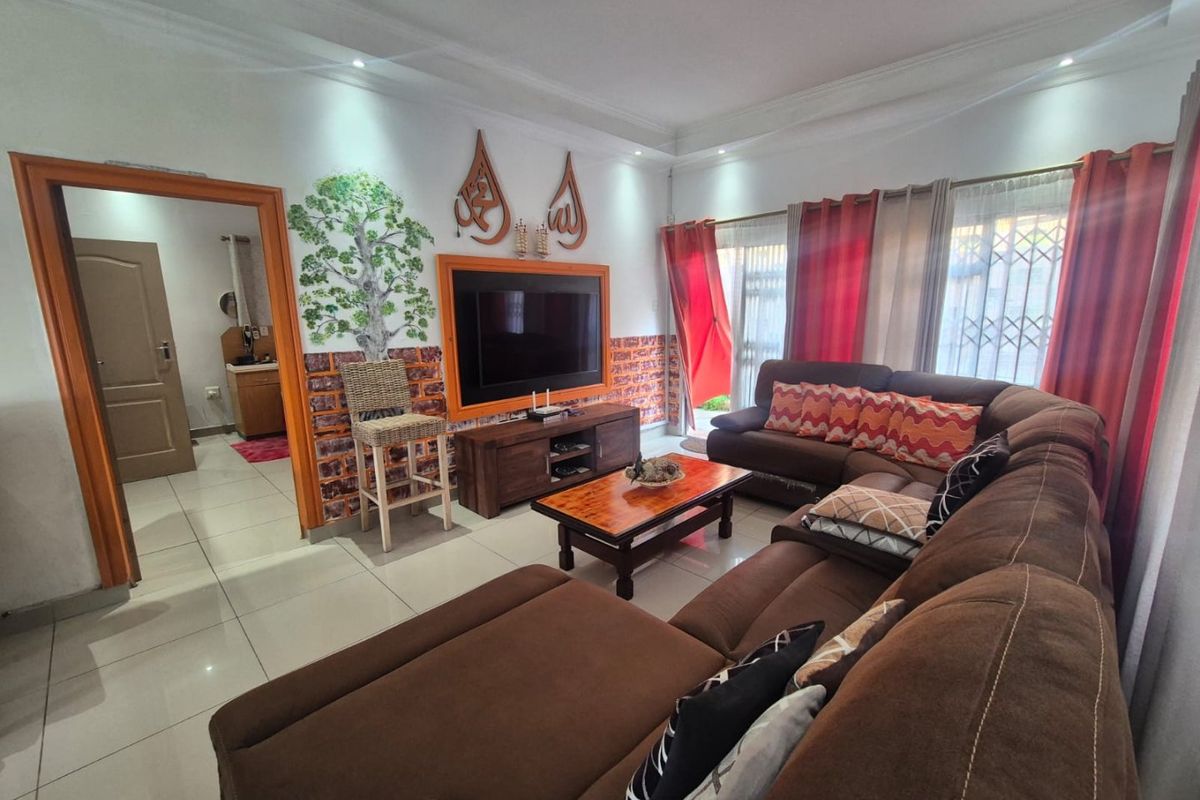 A comfortable living room featuring tiled flooring, recessed downlighting, and a secure entrance, providing a functional and well-maintained space for relaxation.