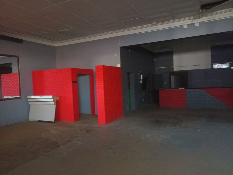 Open plan commercial space featuring a built-in bar counter and brick partition walls, requiring significant refurbishment and cosmetic updates throughout.