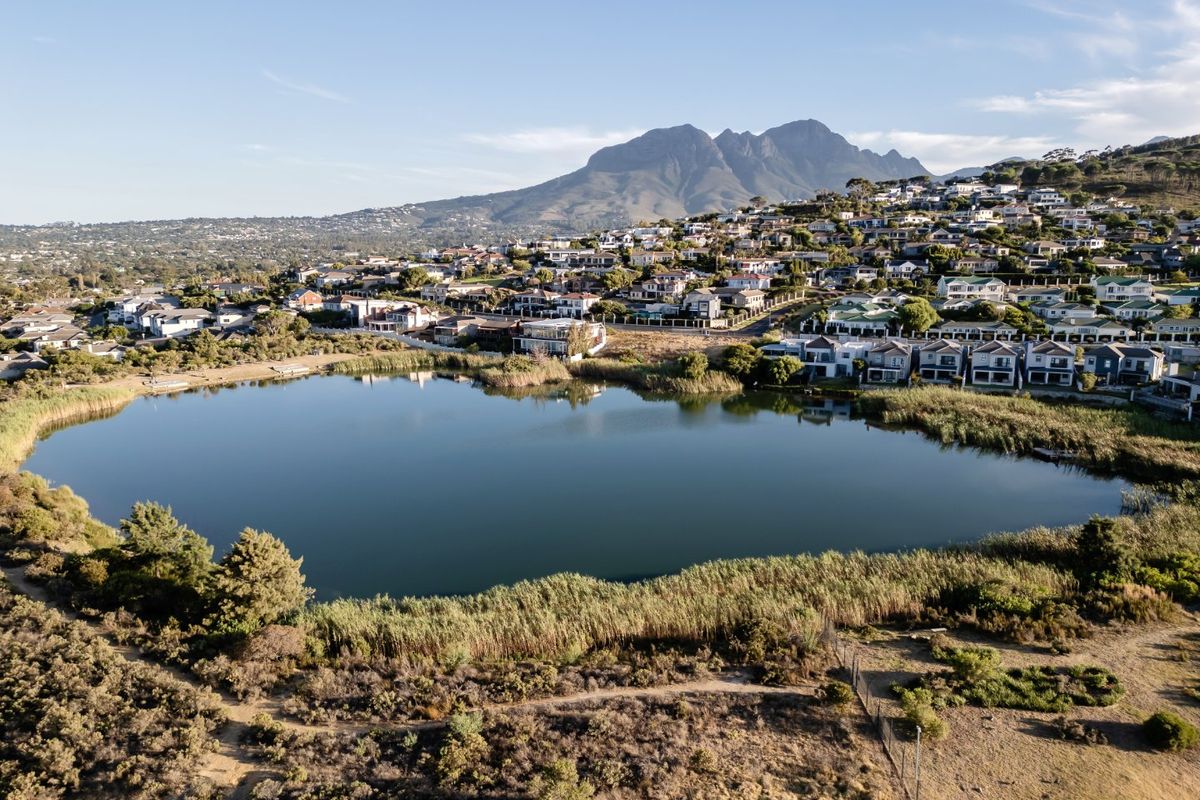An aerial view of the property location, showcasing the surrounding lake, natural landscape, and mountain backdrop.