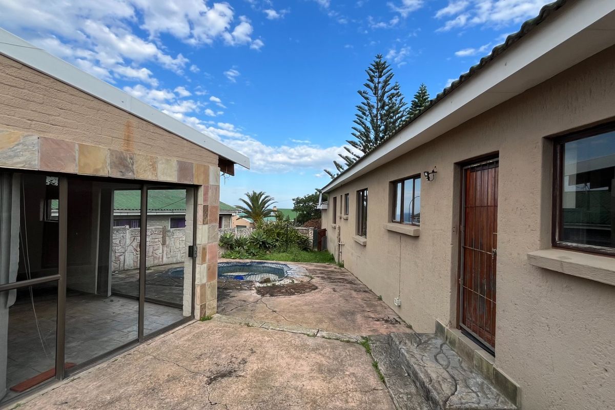 Rear exterior view featuring a concrete patio area, swimming pool, and access to the main dwelling via sliding glass doors.