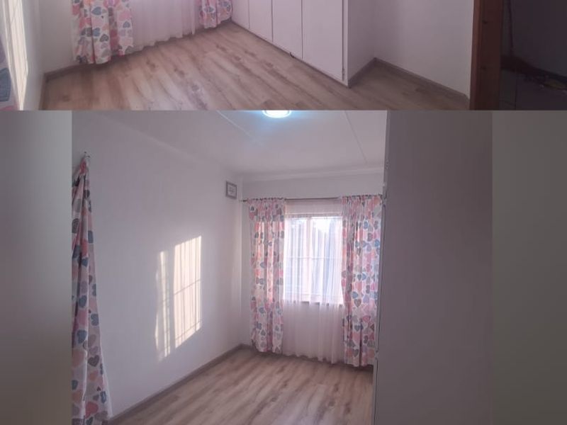 A bright, empty bedroom featuring laminate flooring and built-in cupboards, offering a clean and neutral space ready for personalization.