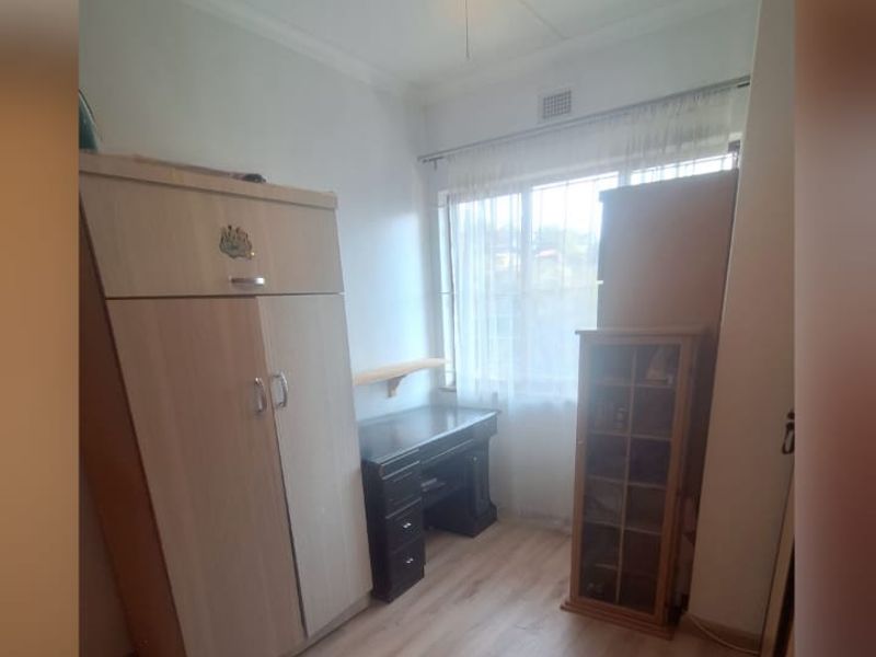 A bedroom featuring laminate flooring and built-in cupboards, providing functional storage space.