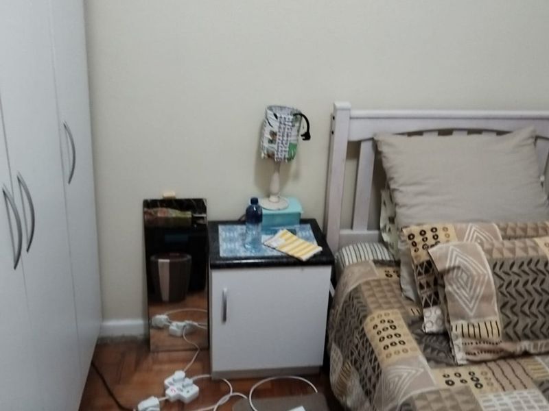 A bedroom featuring parquet flooring and a built-in wardrobe, providing functional storage space.