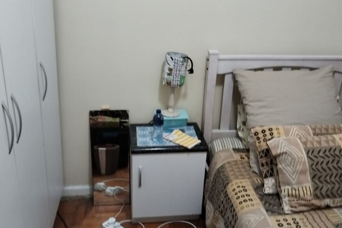A bedroom featuring parquet flooring and a built-in wardrobe, providing functional storage space.