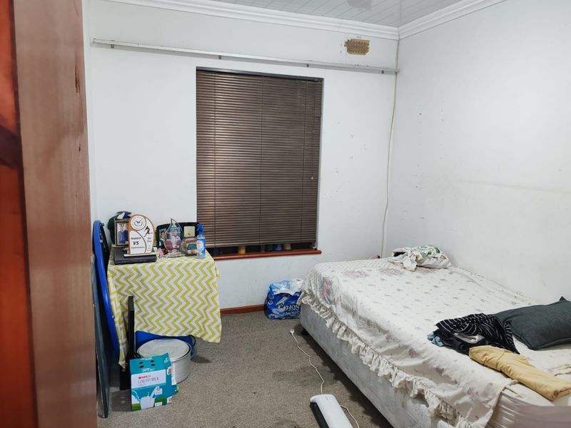 A bedroom featuring carpeted flooring, coved ceilings, and venetian blinds. The room requires cosmetic updates to the wall finishes and flooring.