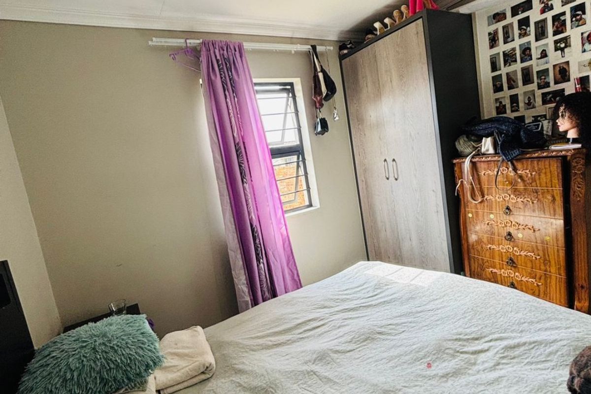 A standard bedroom featuring a built-in wardrobe, louver window, and coved ceiling finishes.