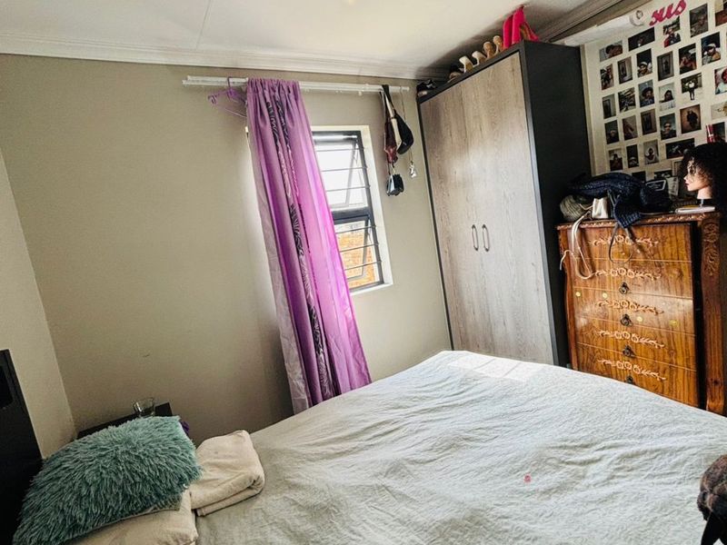 A standard bedroom featuring a built-in wardrobe, louver window, and coved ceiling finishes.