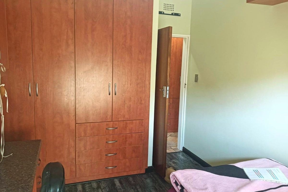 A bedroom featuring extensive built-in wooden cabinetry and a matching built-in desk, providing ample storage and workspace.