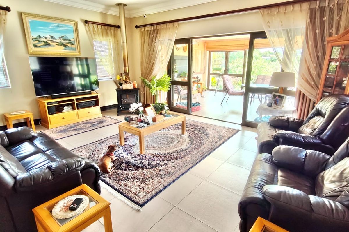 Spacious living room featuring tiled flooring, a freestanding fireplace, and large sliding glass doors that provide seamless access to the outdoor patio area.