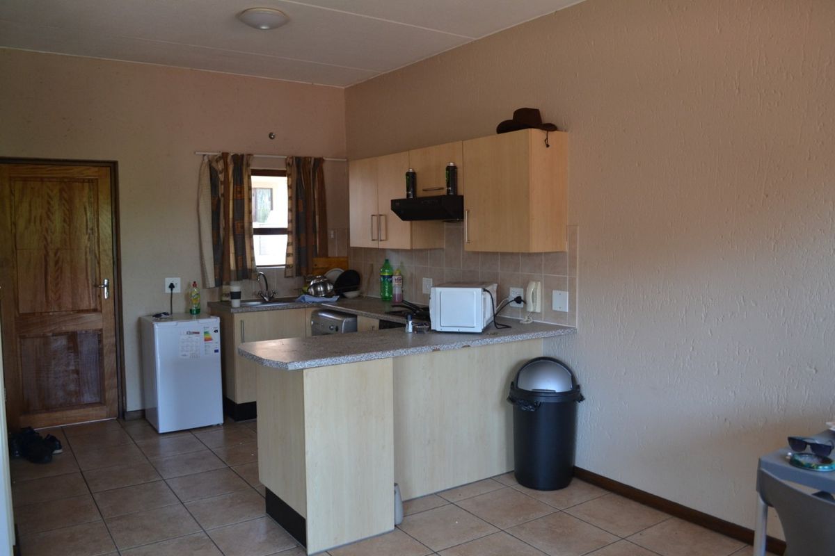 A functional kitchen featuring laminate cabinetry, tiled flooring, and a tiled splashback, offering a practical layout for daily use.