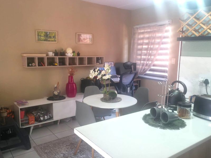 An open-plan living and kitchen area featuring tiled floors, built-in cabinetry, and a functional layout suitable for modern apartment living.