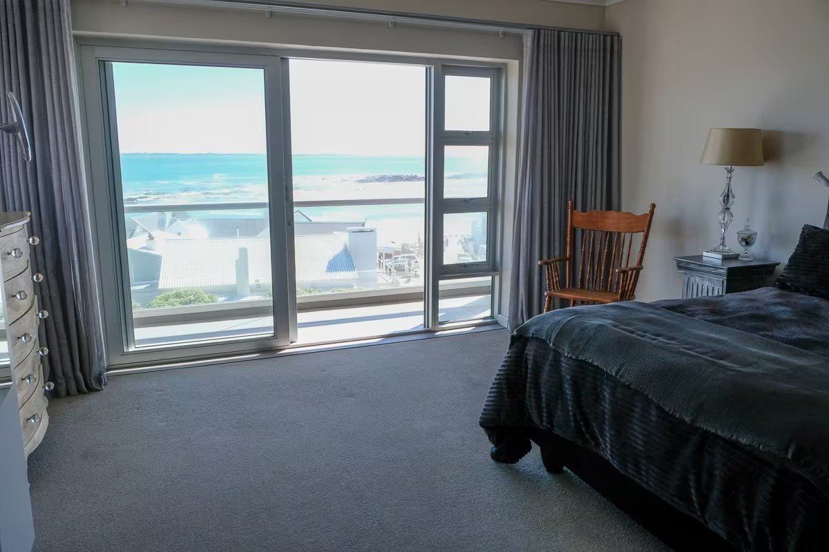 Spacious bedroom featuring large sliding glass doors that provide expansive ocean views and natural light.