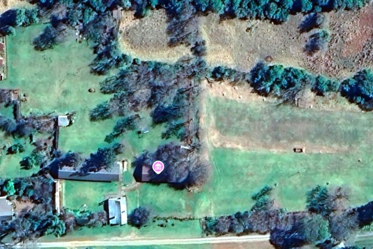 Aerial view of a large farm property featuring multiple outbuildings, expansive grounds, and mature landscaping.