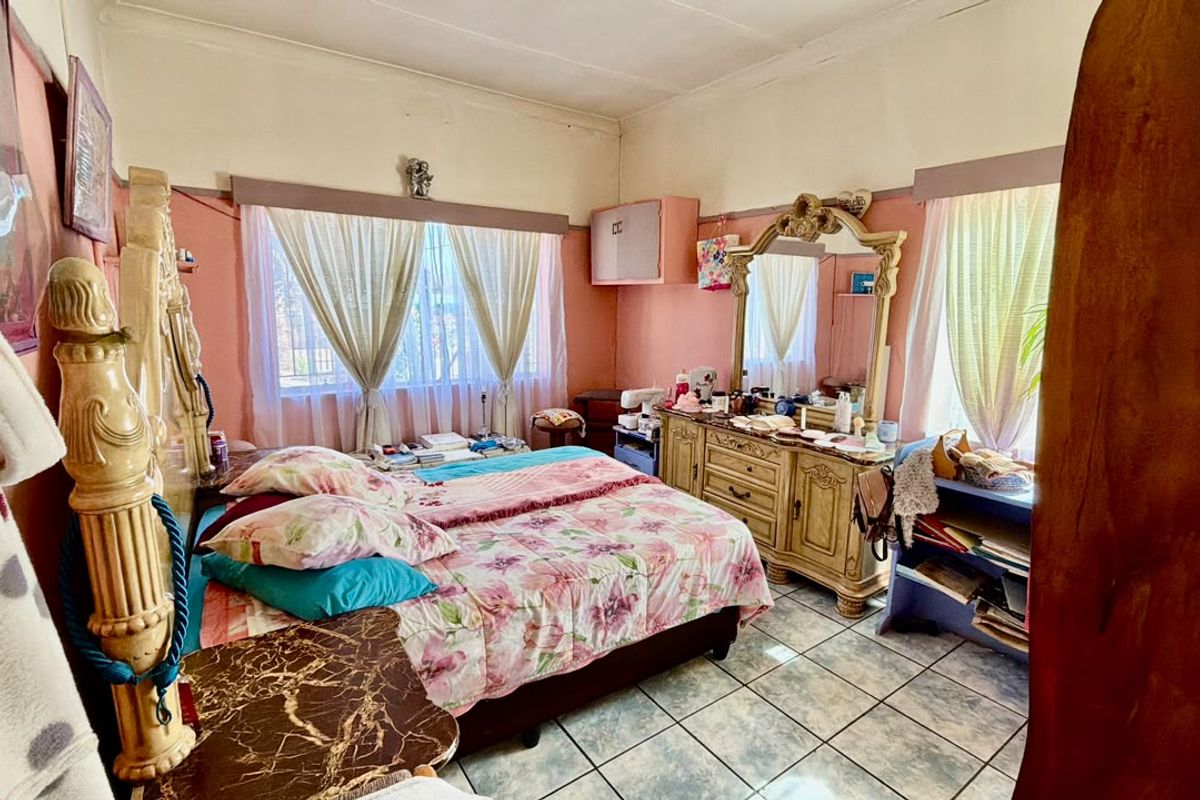 A bedroom featuring tiled flooring and built-in cabinetry, offering a functional space with potential for cosmetic updates to modernize the interior.