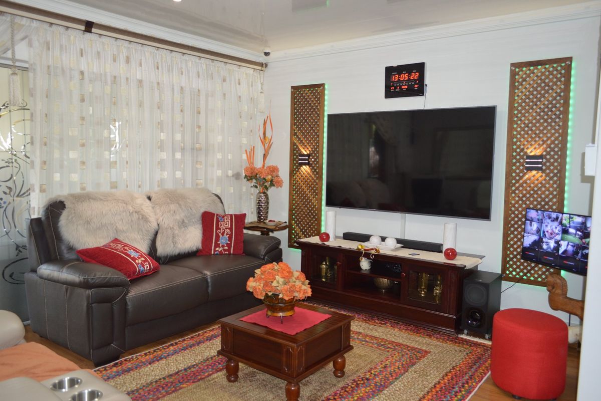 A living room featuring decorative wall panels with integrated lighting, recessed ceiling lights, and coving detail.