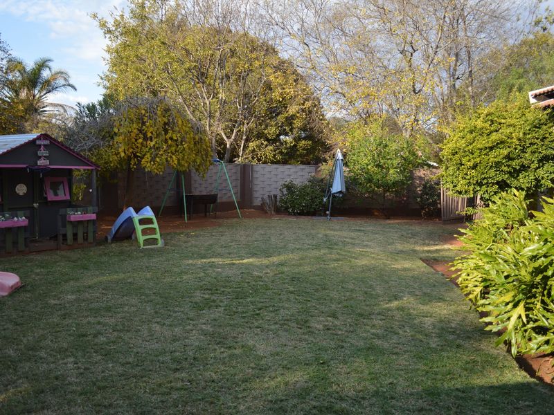 A spacious private garden featuring a well-maintained lawn and perimeter wall, providing a quiet outdoor space for recreation.