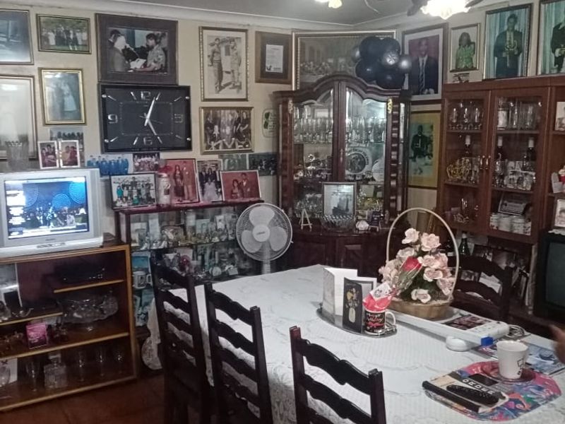 A traditional dining room featuring tiled flooring, a decorative chandelier, and built-in display cabinetry for storage and display.
