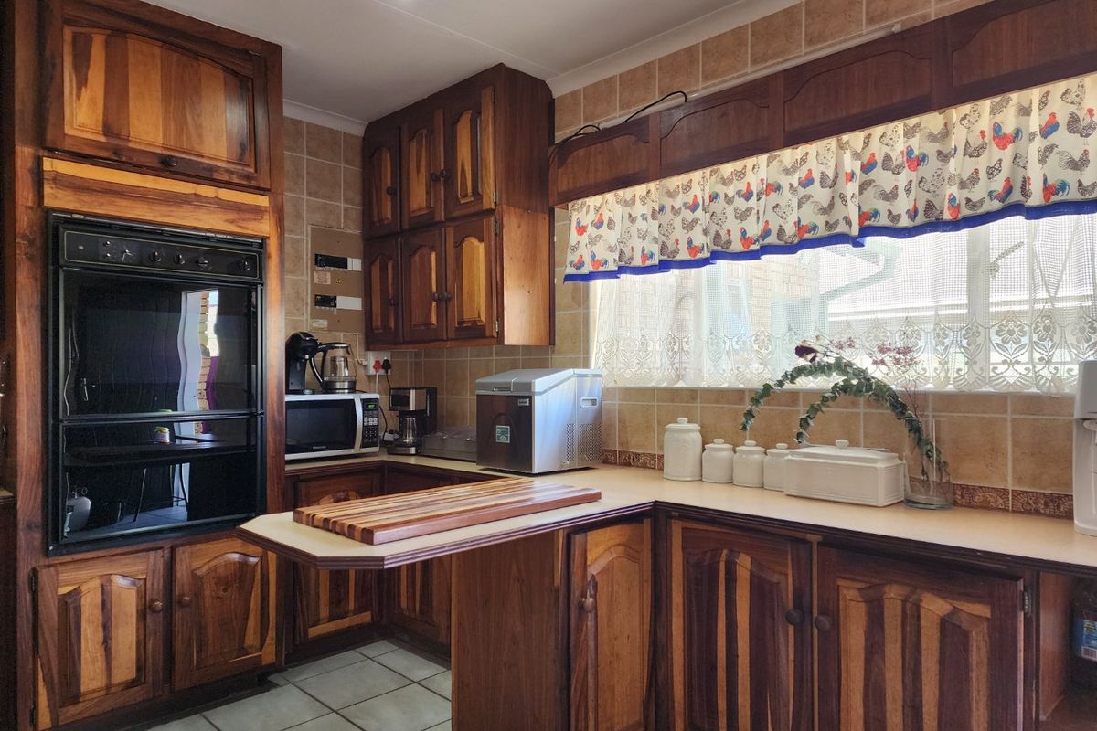 A functional kitchen featuring traditional wooden cabinetry, tiled backsplash, and a built-in oven, offering a classic aesthetic with potential for modern updates.