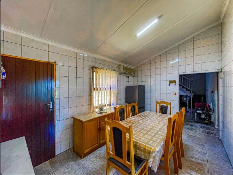 Dining area featuring fully tiled walls, tiled flooring, and a sloped ceiling with an integrated air conditioning unit.