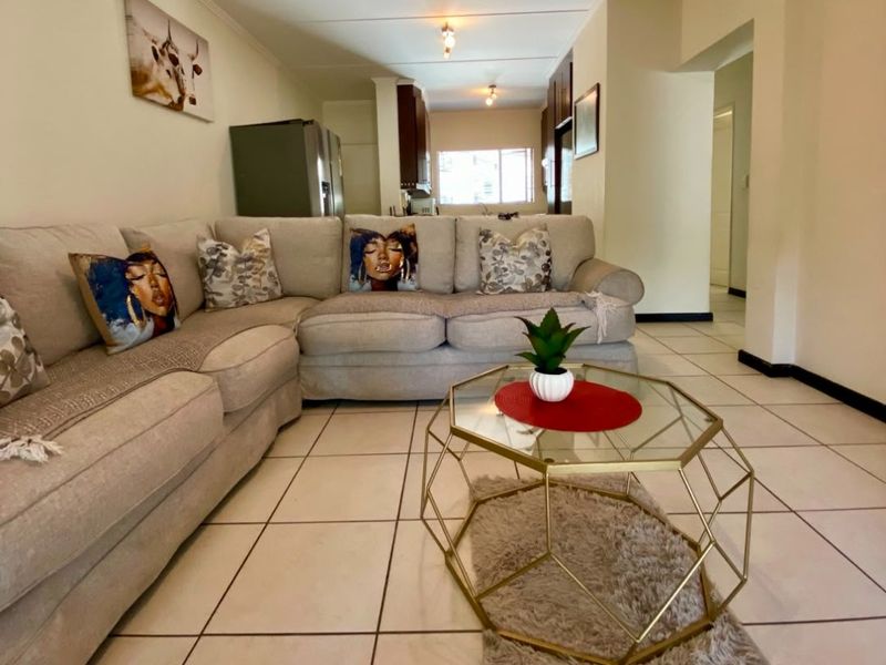 Open-plan living area featuring tiled flooring and a direct view into the kitchen space.