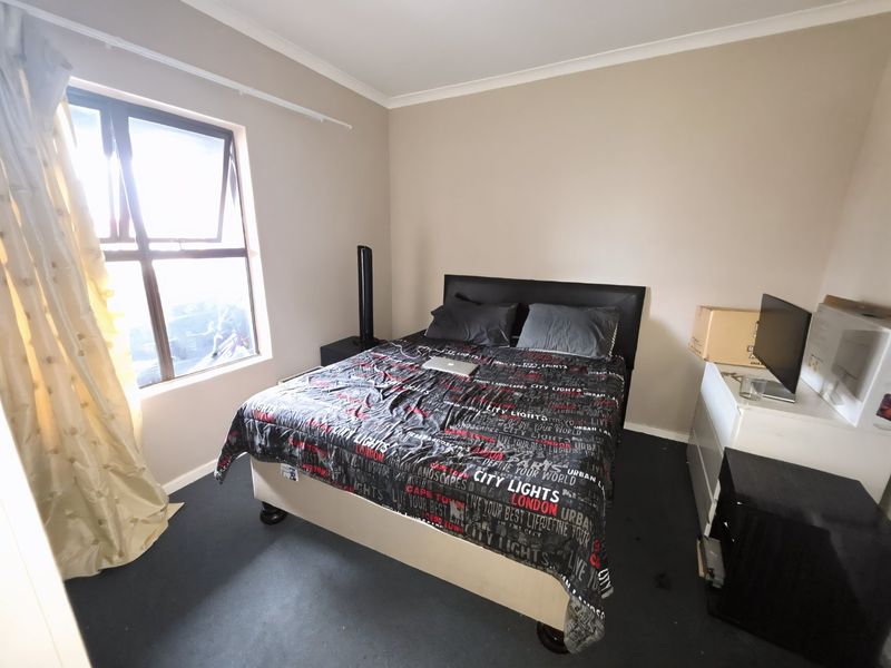 A standard bedroom featuring a casement window and neutral wall finishes, providing a functional space for rest.