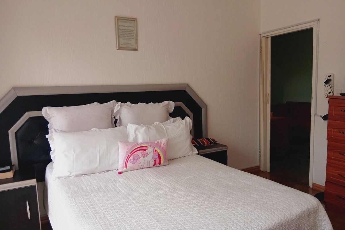 A bedroom featuring a built-in headboard and a folding door leading to an adjacent space.