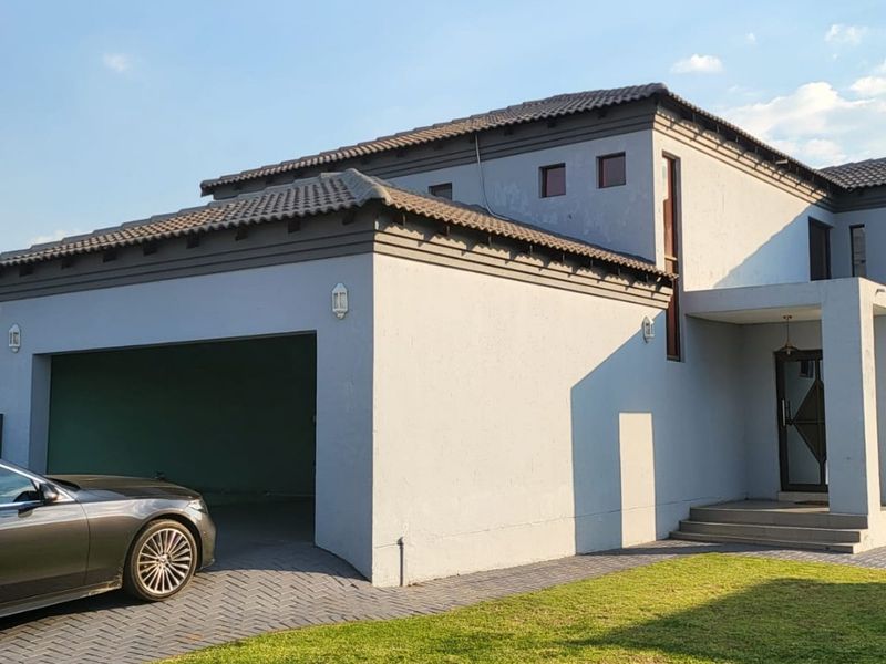 Front elevation of a modern double-story house featuring a paved driveway, double garage, and a covered entrance with concrete steps.