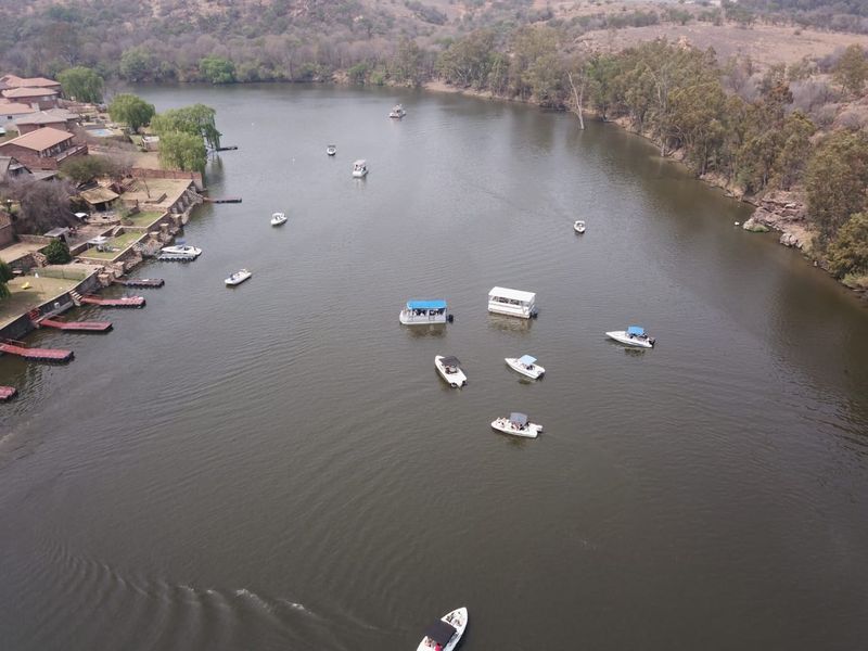 Aerial view of the riverfront area showing residential properties with private jetties and recreational boating activity on the water.