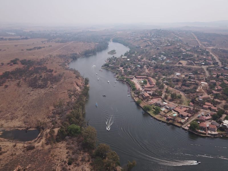 An aerial view of a river landscape featuring surrounding residential properties and natural terrain.