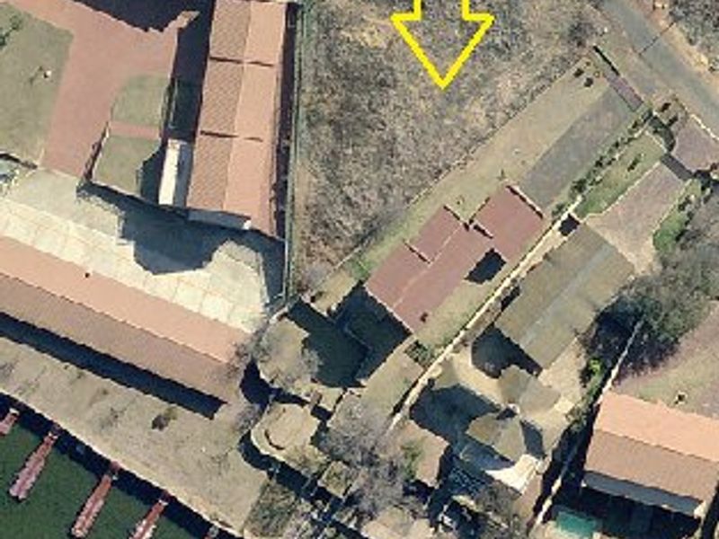 Aerial view of a vacant residential plot situated in a waterfront estate, highlighting the land parcel and surrounding neighborhood layout.