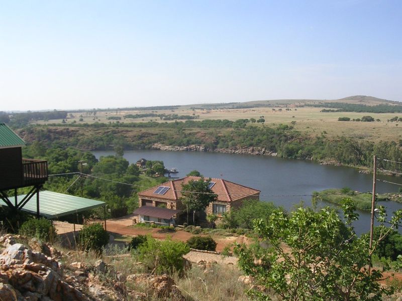 Elevated scenic view overlooking a river and surrounding natural landscape with residential properties visible in the distance.