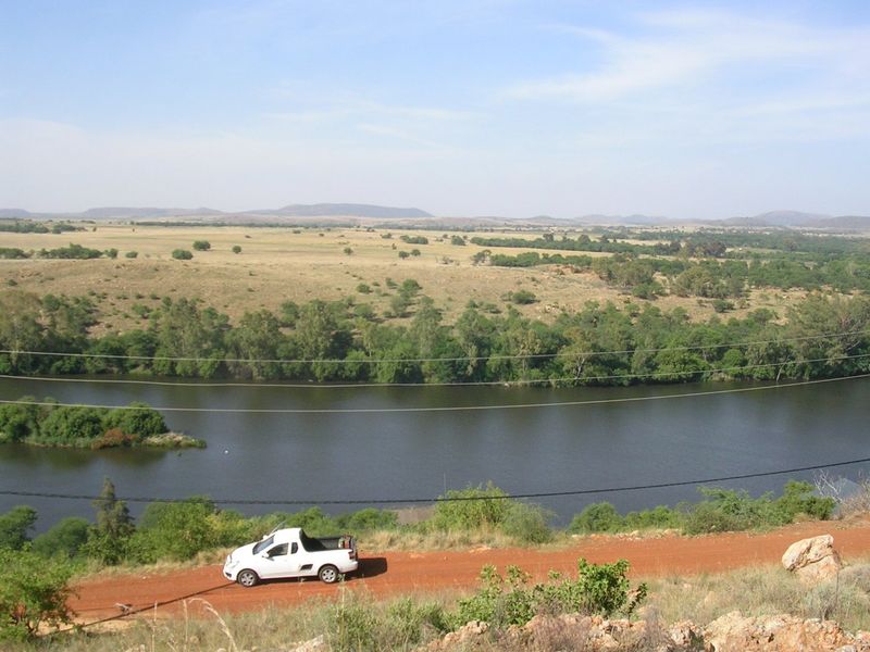A scenic elevated view overlooking a river and expansive natural landscape, showcasing the property's tranquil surroundings.