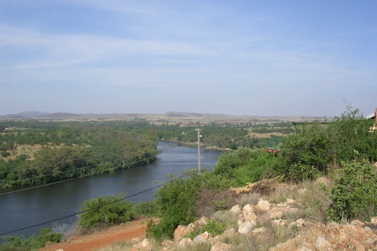 A scenic elevated view overlooking a river winding through a natural landscape with surrounding vegetation and hills.