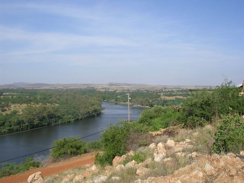 A scenic elevated view overlooking a river winding through a natural landscape with surrounding vegetation and hills.