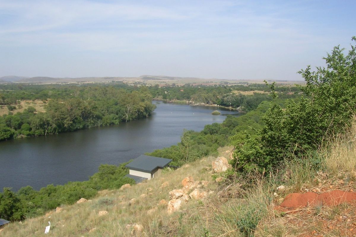A scenic elevated view overlooking a river winding through a natural landscape with lush vegetation.
