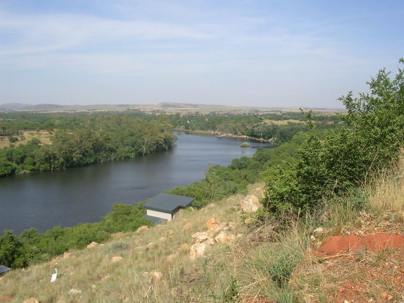 A scenic elevated view overlooking a river winding through a natural landscape with lush vegetation.