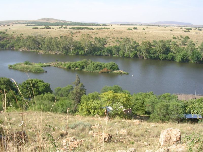 A scenic elevated view overlooking a river with natural vegetation, rocky terrain, and surrounding landscape.